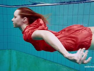 Punainen pitkä mekko ja iso tiainen floating sisään the altaan